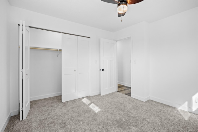 unfurnished bedroom with a closet, ceiling fan, baseboards, and carpet