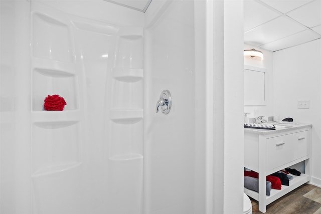 bathroom with vanity, wood finished floors, and a shower stall