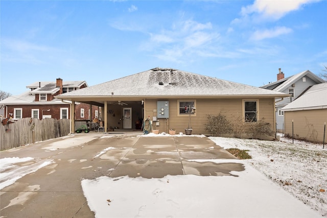 snow covered back of property with ceiling fan, a patio area, and fence