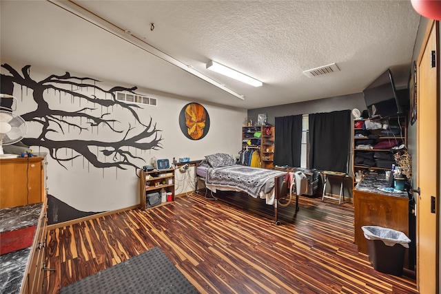 bedroom featuring a textured ceiling, visible vents, and wood finished floors