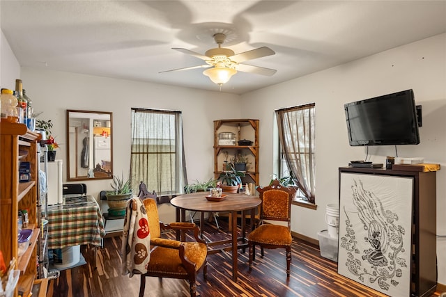 dining space with a ceiling fan, baseboards, and wood finished floors