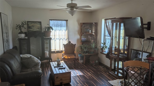 living room featuring ceiling fan, baseboards, and wood finished floors