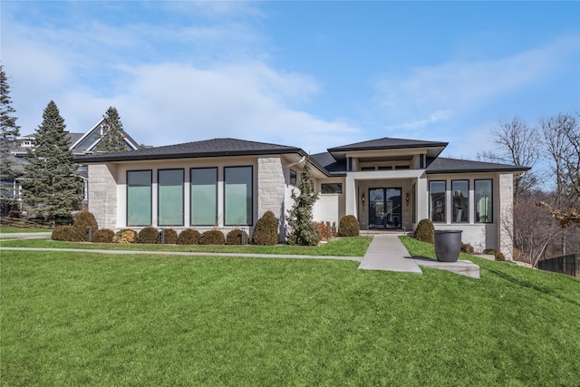 prairie-style home with stone siding and a front yard