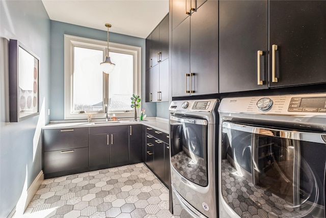 laundry room with a sink, washing machine and dryer, and cabinet space