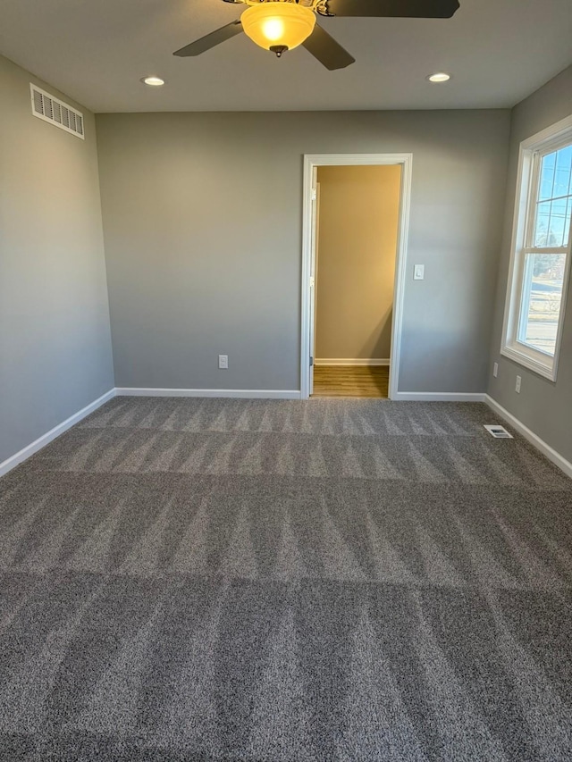 unfurnished room with carpet, visible vents, baseboards, and recessed lighting