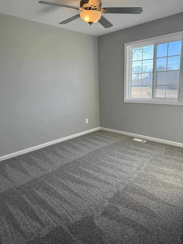 empty room with carpet flooring, ceiling fan, and baseboards