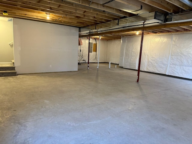 unfinished basement with electric panel and stairway