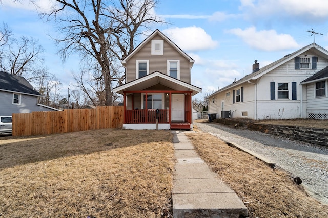 view of front of home featuring central AC, a porch, a front yard, and fence