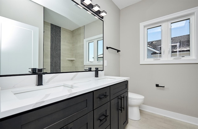 bathroom featuring a wealth of natural light, a sink, and toilet