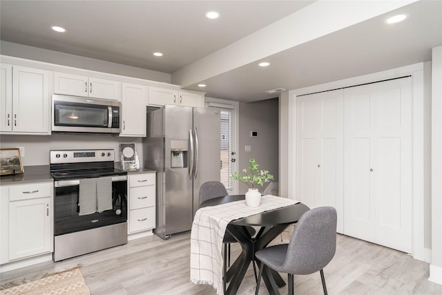 kitchen with appliances with stainless steel finishes, light wood-type flooring, and recessed lighting