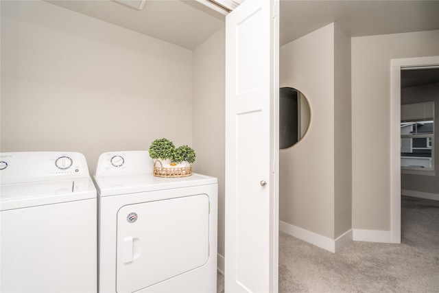 washroom with laundry area, light carpet, baseboards, and washing machine and clothes dryer