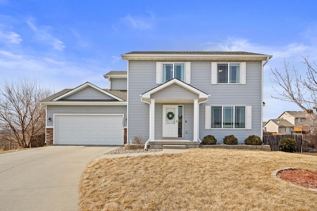 traditional-style house with concrete driveway, an attached garage, fence, and a front yard