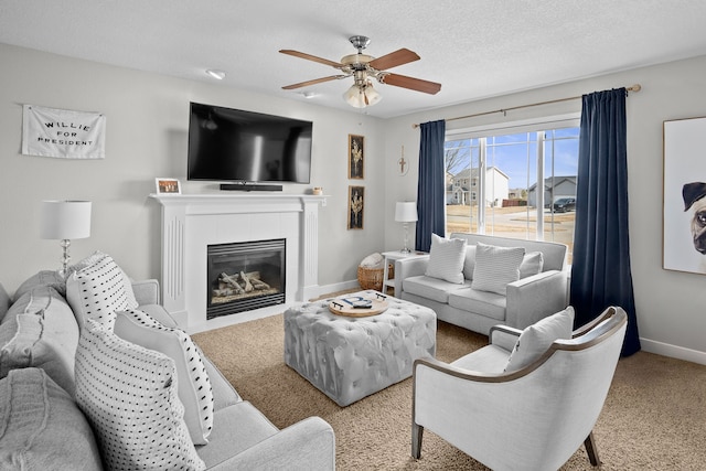 living area featuring a tile fireplace, a textured ceiling, baseboards, and a ceiling fan