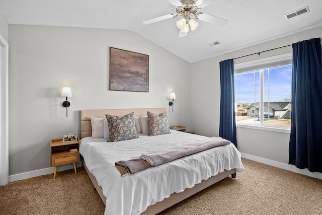 carpeted bedroom with vaulted ceiling, baseboards, and visible vents