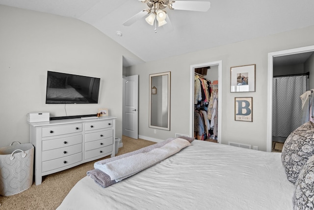 bedroom with lofted ceiling, ceiling fan, a spacious closet, a closet, and light colored carpet