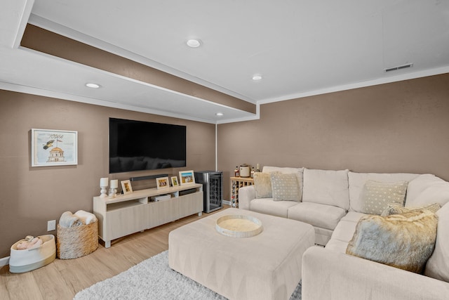 living room featuring recessed lighting, wood finished floors, visible vents, and ornamental molding