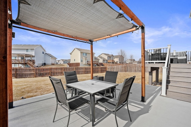 view of patio featuring a fenced backyard, a residential view, outdoor dining space, and stairway