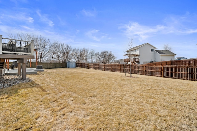 view of yard with a patio area, cooling unit, a fenced backyard, an outbuilding, and a storage unit