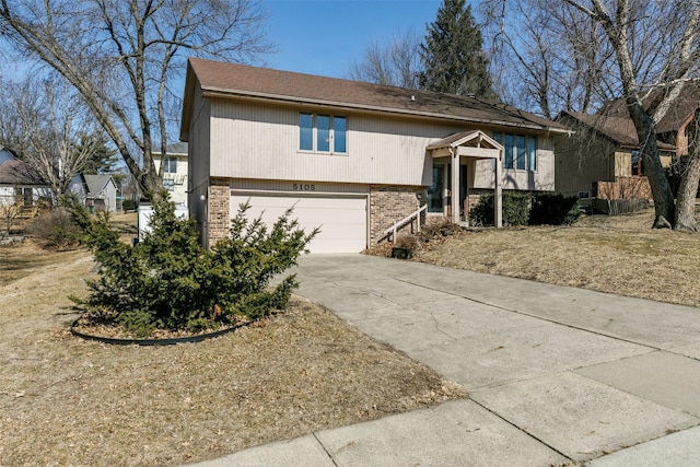 view of front of home featuring driveway, a garage, and brick siding