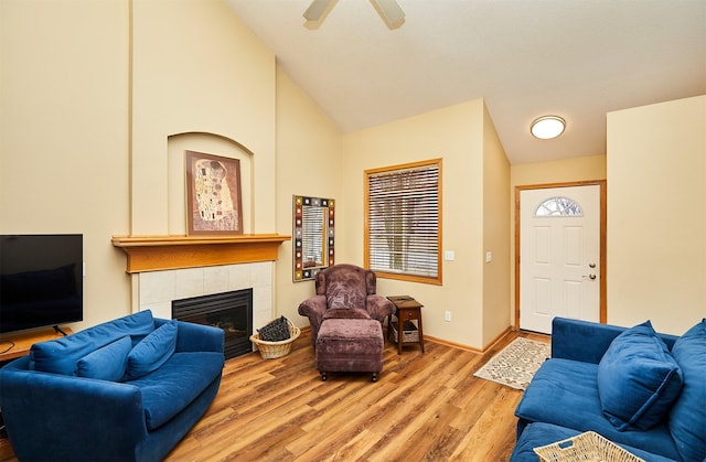 living room featuring baseboards, a ceiling fan, lofted ceiling, wood finished floors, and a fireplace