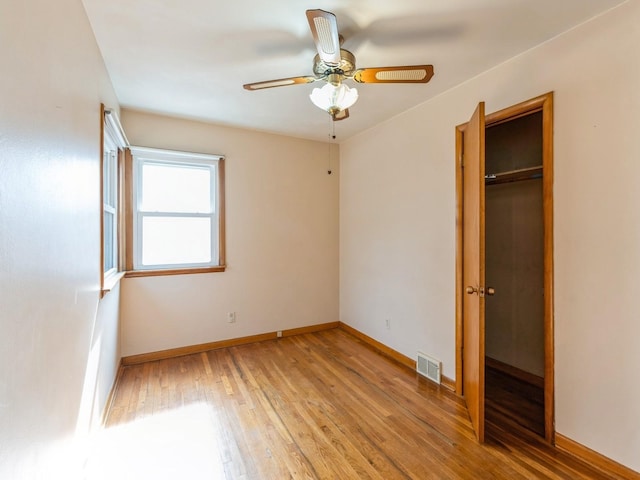 unfurnished bedroom with light wood-type flooring, baseboards, visible vents, and a closet