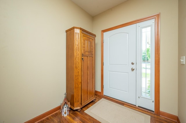 foyer featuring dark wood-style flooring and baseboards