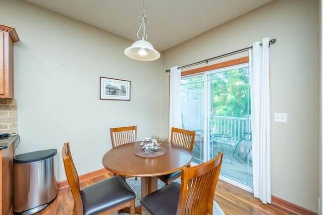 dining space with baseboards and wood finished floors