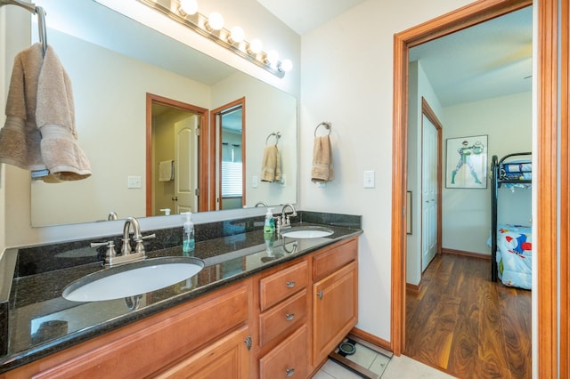 bathroom featuring double vanity, a sink, and baseboards