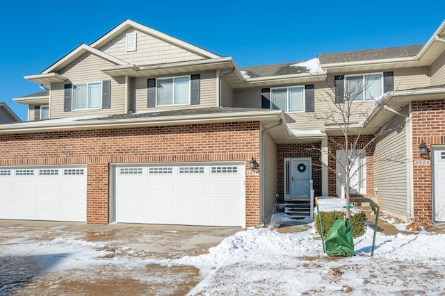 view of front of house featuring a garage, brick siding, driveway, and roof with shingles