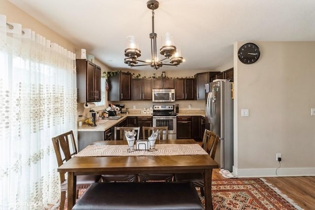 dining area featuring baseboards, a notable chandelier, and wood finished floors