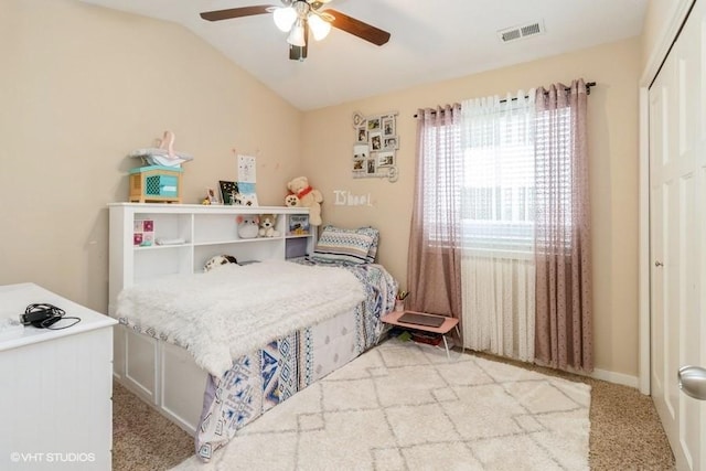 bedroom featuring visible vents, light colored carpet, lofted ceiling, ceiling fan, and a closet