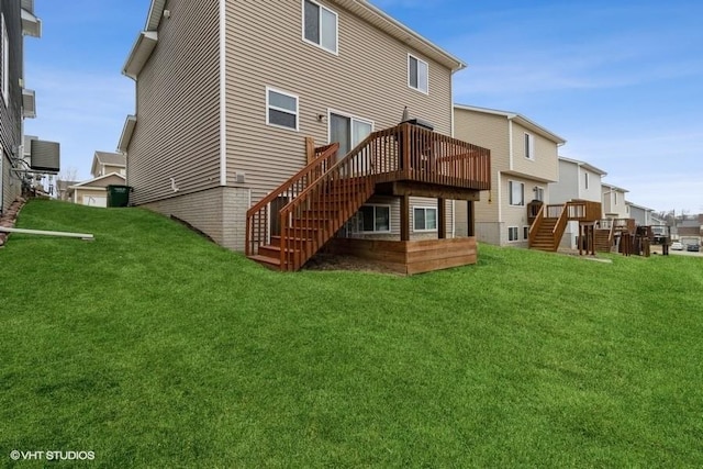 rear view of house with stairs, a deck, and a lawn