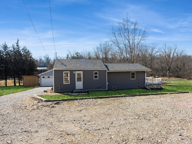 single story home featuring roof with shingles, dirt driveway, and an outdoor structure