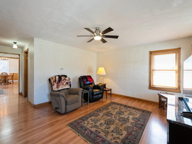 sitting room with light wood finished floors, ceiling fan, and baseboards