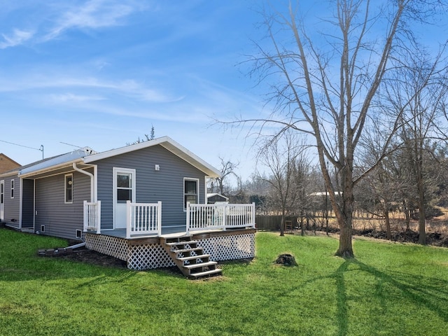 back of house featuring a deck and a lawn