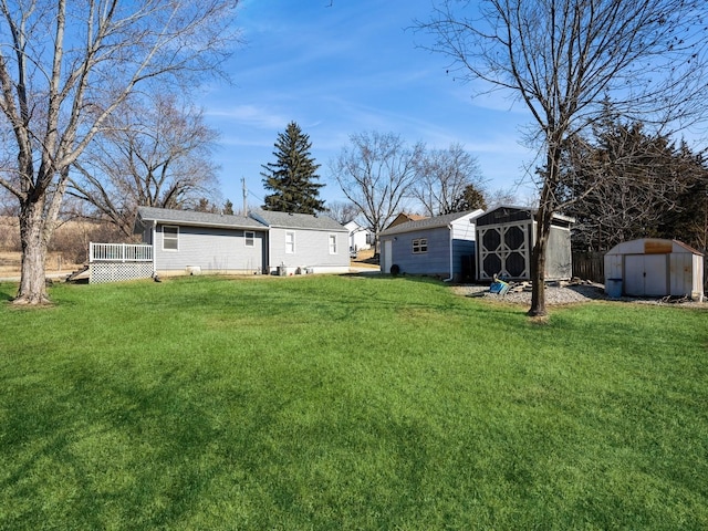 view of yard featuring an outbuilding, a deck, and a storage unit