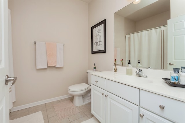 bathroom with baseboards, vanity, toilet, and tile patterned floors