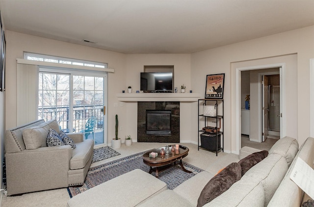 living room with carpet floors, baseboards, visible vents, and a tile fireplace