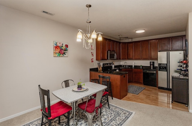 kitchen featuring visible vents, baseboards, dark countertops, appliances with stainless steel finishes, and a peninsula