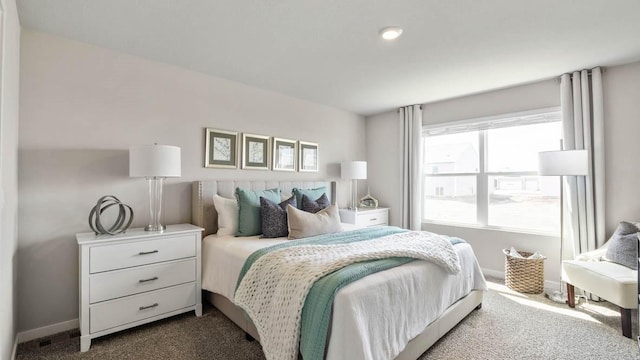 bedroom featuring dark carpet and baseboards