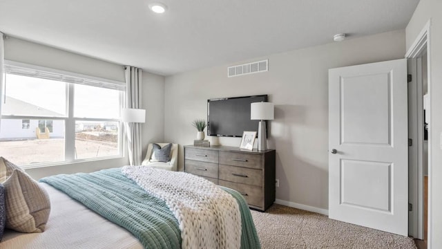 bedroom with light carpet, visible vents, and baseboards