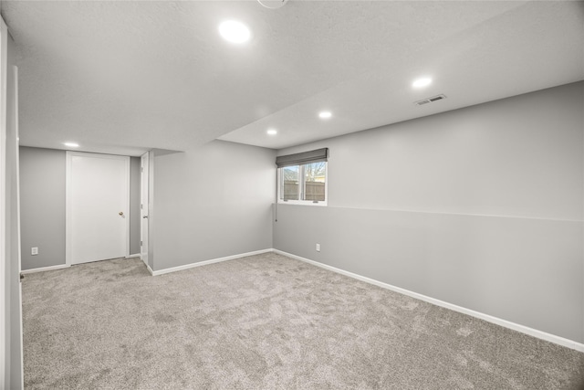 below grade area with a textured ceiling, recessed lighting, visible vents, baseboards, and carpet