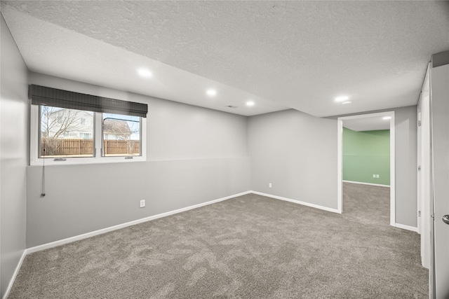 below grade area featuring carpet, a textured ceiling, baseboards, and recessed lighting