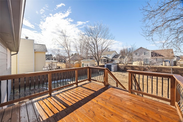 wooden terrace with a storage shed, an outbuilding, a fenced backyard, and a residential view