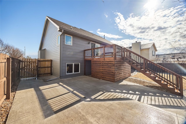 back of house featuring a patio, a gate, fence, a wooden deck, and stairs