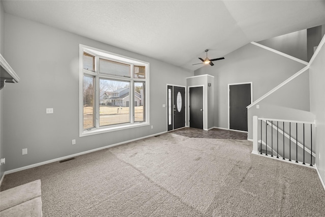 unfurnished living room featuring visible vents, baseboards, lofted ceiling, carpet, and a textured ceiling