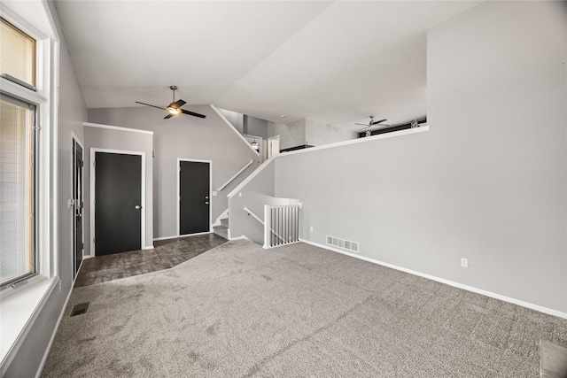 carpeted spare room featuring visible vents, stairway, lofted ceiling, and a ceiling fan