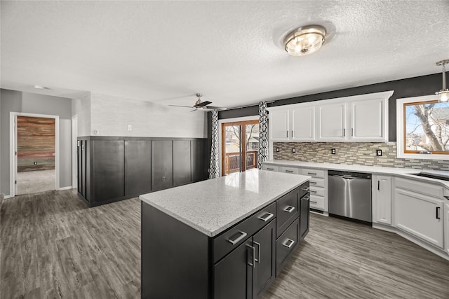 kitchen with dishwasher, wood finished floors, white cabinetry, and a center island