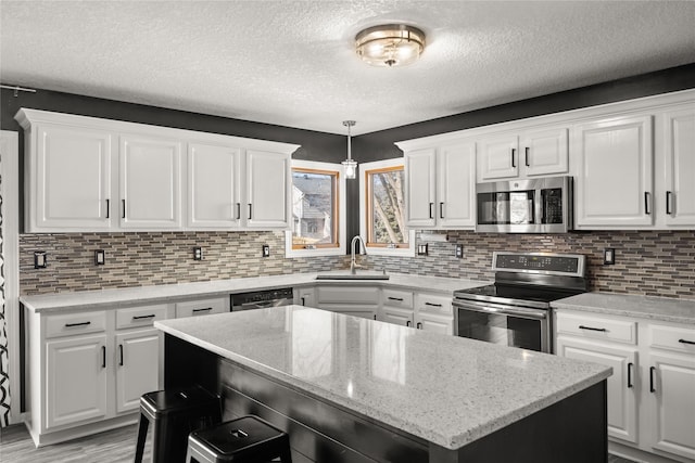 kitchen with appliances with stainless steel finishes, a sink, and white cabinets