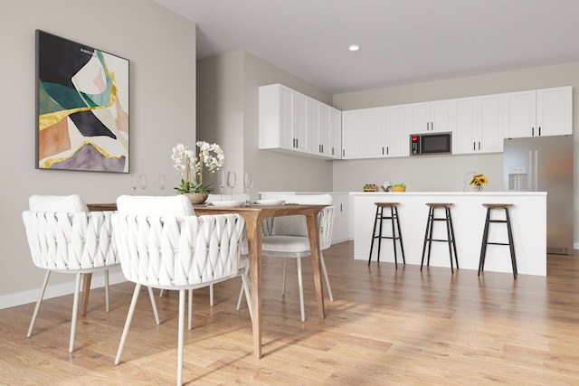 1310 Murphy St Unit 1206, Des Moines, IA 50309 - kitchen with recessed lighting, light wood-style flooring, white cabinetry, stainless steel fridge, and baseboards